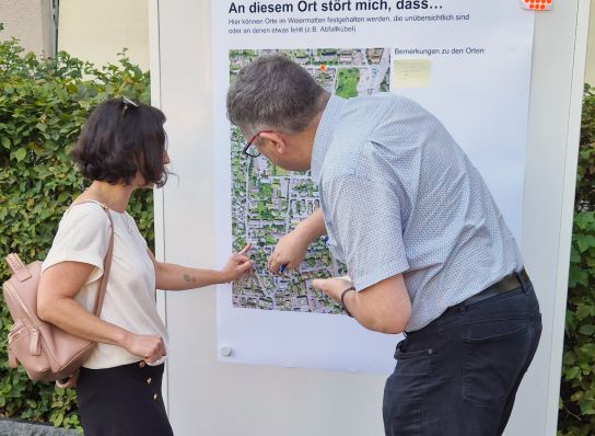 Der für Mobiltät Zuständige erklärt einer Anwohnerin die Bus-58-Strecke