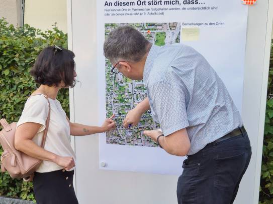 Der für Mobiltät Zuständige erklärt einer Anwohnerin die Bus-58-Strecke